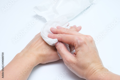 Woman hands using wet cleaning antibacterial wipes, white background, hygiene and body care concept