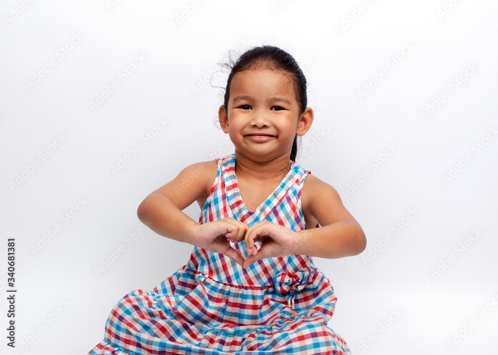 Cute asian baby girl portrait sitting with smile and show heart hands gesture on white backgrounds Cute asian baby girl portrait sitting with smile and show heart hands gesture on white backgrounds