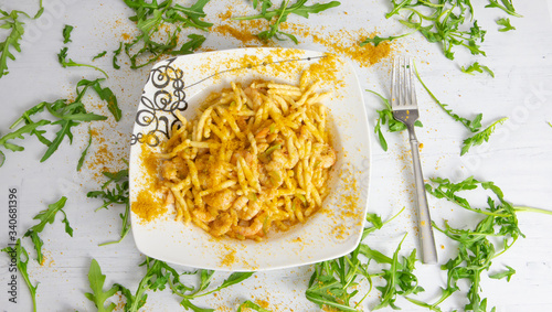 Fotografia trofie con zucchine gamberi e bottarga su e sfondo bianco