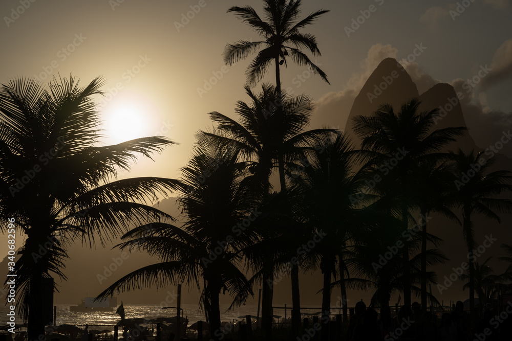 Obraz premium Silhouettes of palm trees on the Ipanema beach during sunset
