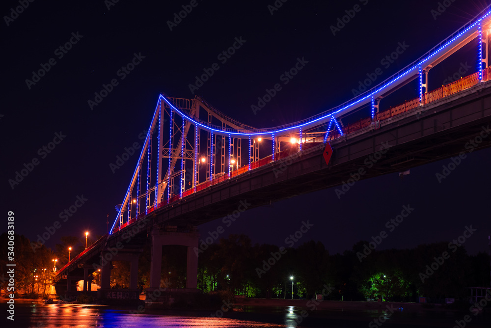 Obraz premium Night view of pedestrian bridge on Dnipro in Kiev Ukraine