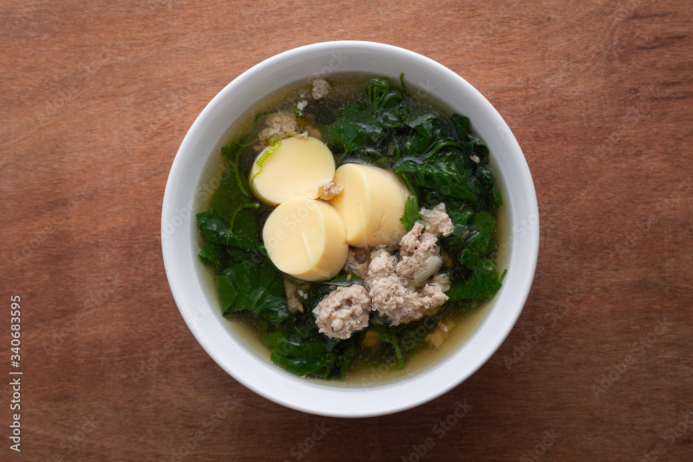 Boiled minced pork and tofu soup with gourd in white bowl on wooden table, Thai food, Healthy food. Boiled minced pork and tofu soup with gourd in white bowl on wooden table, Thai food, Healthy food.