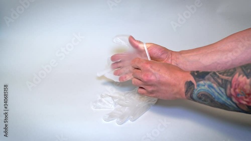 Tattooist with gloves. Close-up of a professional tattooist with gloves. Man with tattoo puts on protective gloves. Medical healthcare. Covid-19 protection.