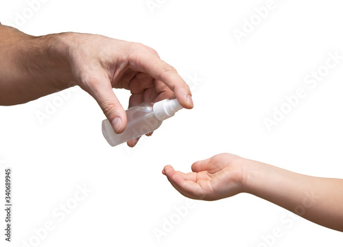 man applying sanitizer on the hands of a child