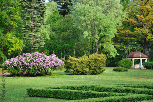 Beautiful park with green lawn, trees and elegant gazebo for romantic encounters