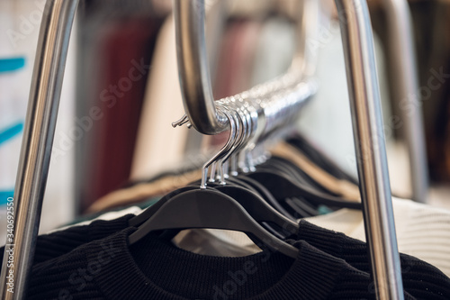 Clothes hanging on black hangers in a fashion store © Anna Kosolapova