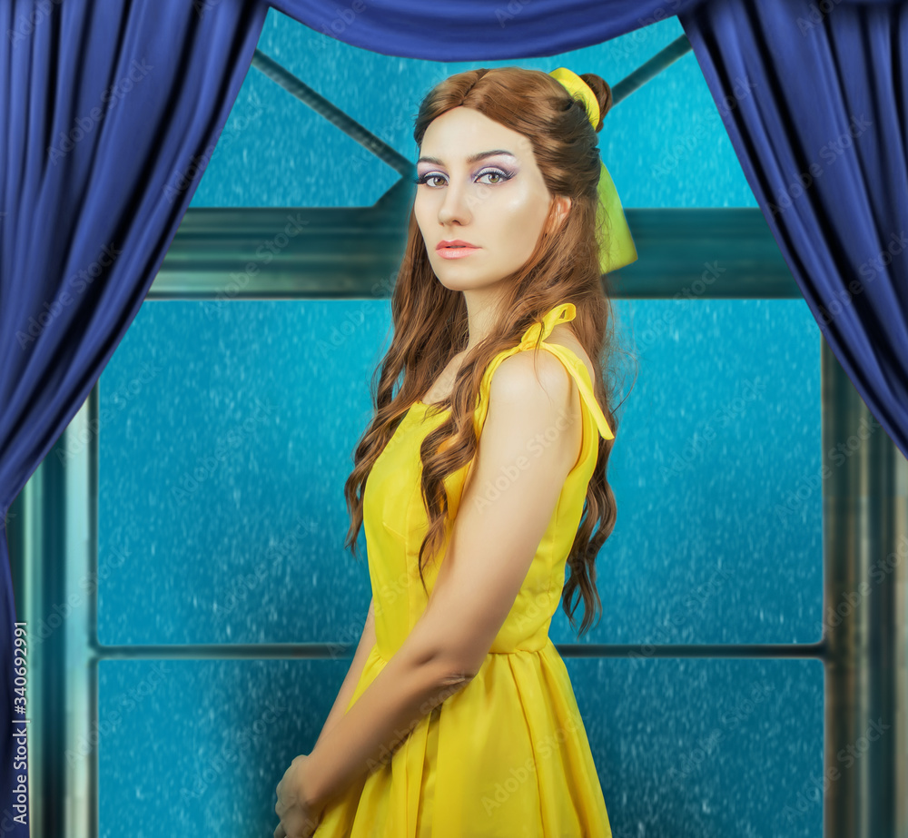 Pretty woman in the yellow long dress closeup on the window background. Beauty and the beast cosplay art processing.