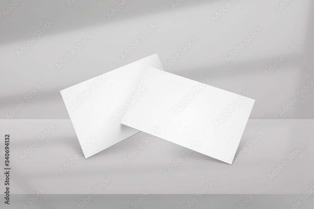 Clean minimal white business card mockup with window shadow and grey background. Clean minimal white business card mockup with window shadow and grey background.