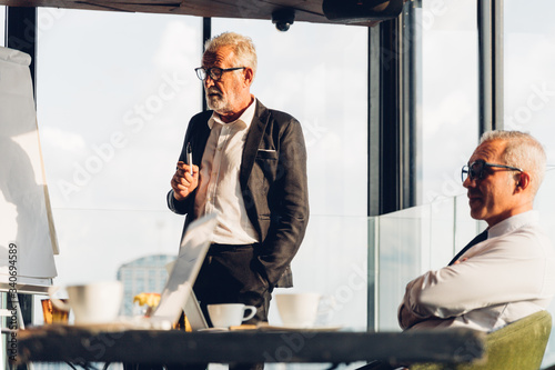 Foto Business man coach speaker wear suit give blank flipchart presentation, Speaker presenter consulting training persuading employees client group, Business meeting, seminar, presentation concept