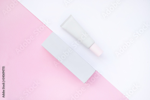 Mockup de frasco de crema y caja de color rosa y blanco sobre fondo de color photo