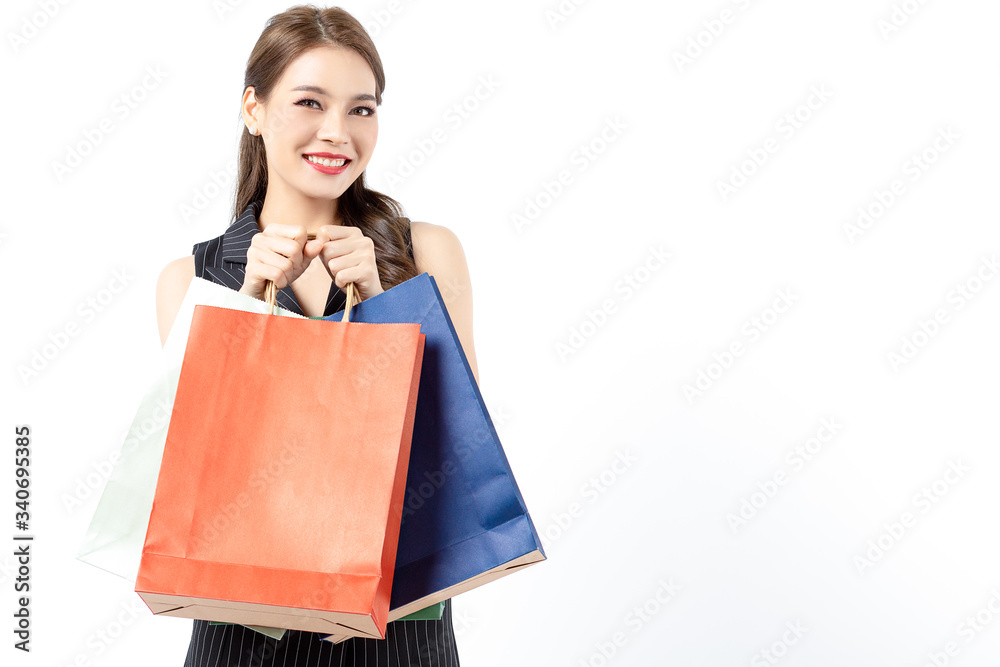 Portrait of young beautiful asian girl wearing black dress holding shopping bags and smile isolated over white background. Online shopping and black friday concept. Portrait of young beautiful asian girl wearing black dress holding shopping bags and smile isolated over white background. Online shopping and black friday concept.