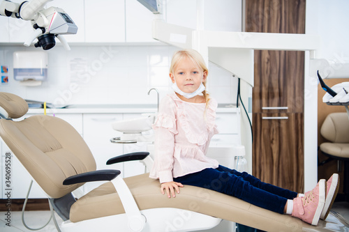 A close-up of a little girl in a dentist office. Children visiting dentists concept. Teeth healthcare concept