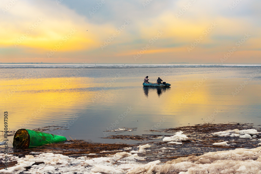 fishermen in a boat at sunset on the Baltic Sea