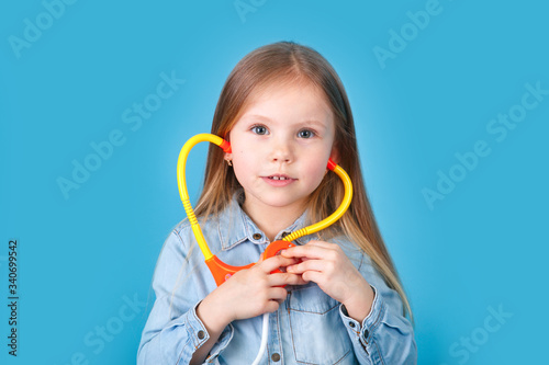 Cute child with stethoscope on color background