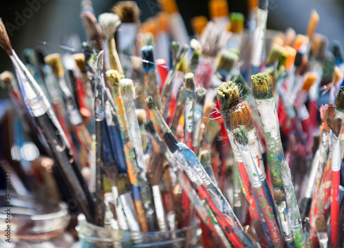 A lot dirty artist paint brushes in a bucket