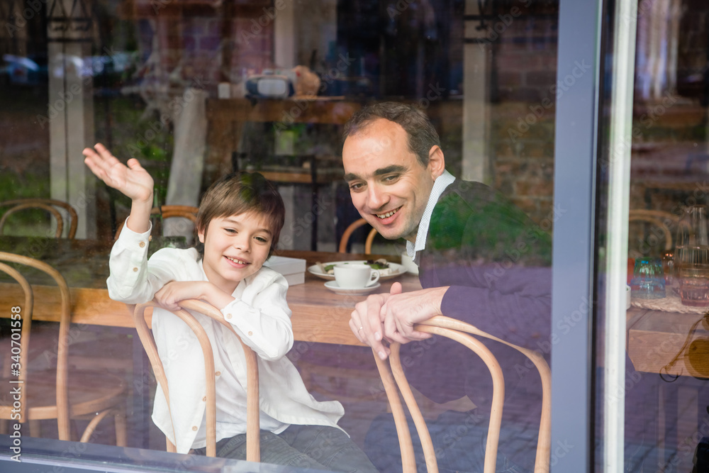 Obraz premium Father and son sitting at the table on a porch