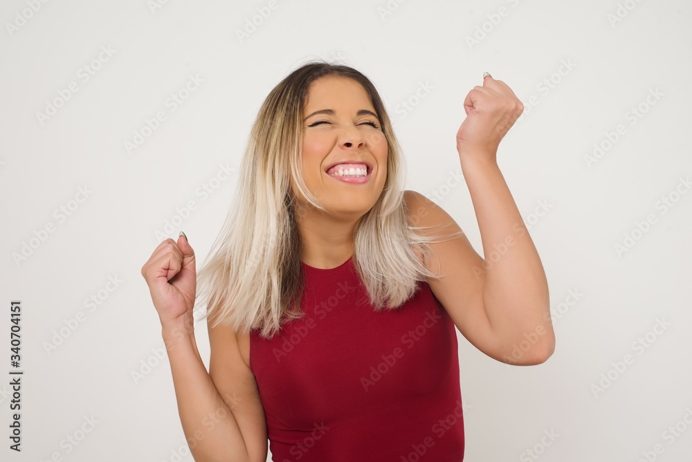 Caucasian brunette woman rejoicing her success and victory clenching her fists with joy. Lucky woman being happy to achieve her aim and goals. Positive emotions, feelings. Caucasian brunette woman rejoicing her success and victory clenching her fists with joy. Lucky woman being happy to achieve her aim and goals. Positive emotions, feelings.