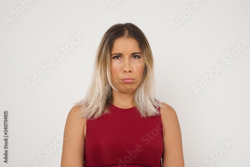 Beautiful face of sad woman crying desperate and depressed with tears on her eyes suffering pain and depression isolated on grey background in sadness facial expression and emotion concept. © Jihan