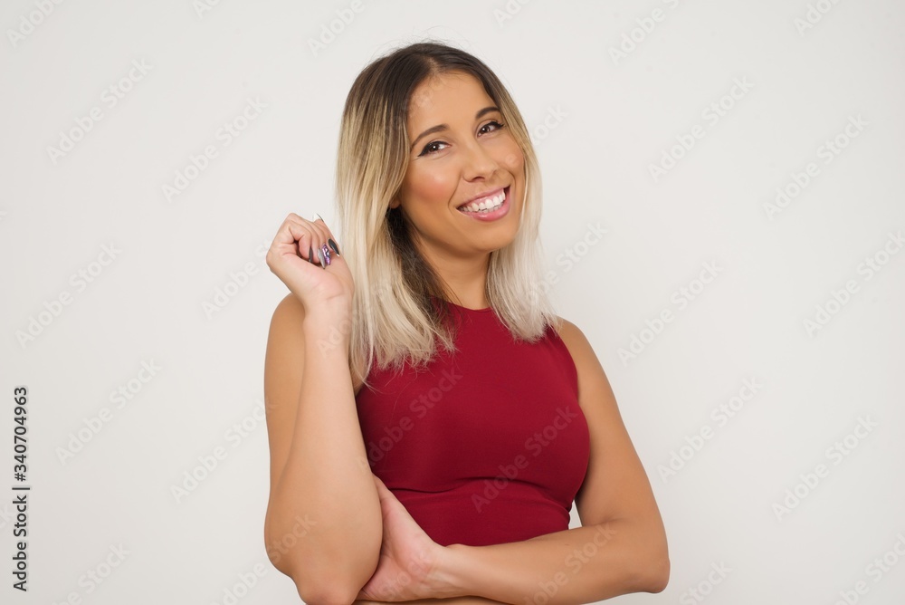 Image of cheerful pretty young caucasian lady standing against gray wall with hand near face. Looking with glad expression at the camera after listening to good news. Confident girl. Image of cheerful pretty young caucasian lady standing against gray wall with hand near face. Looking with glad expression at the camera after listening to good news. Confident girl.