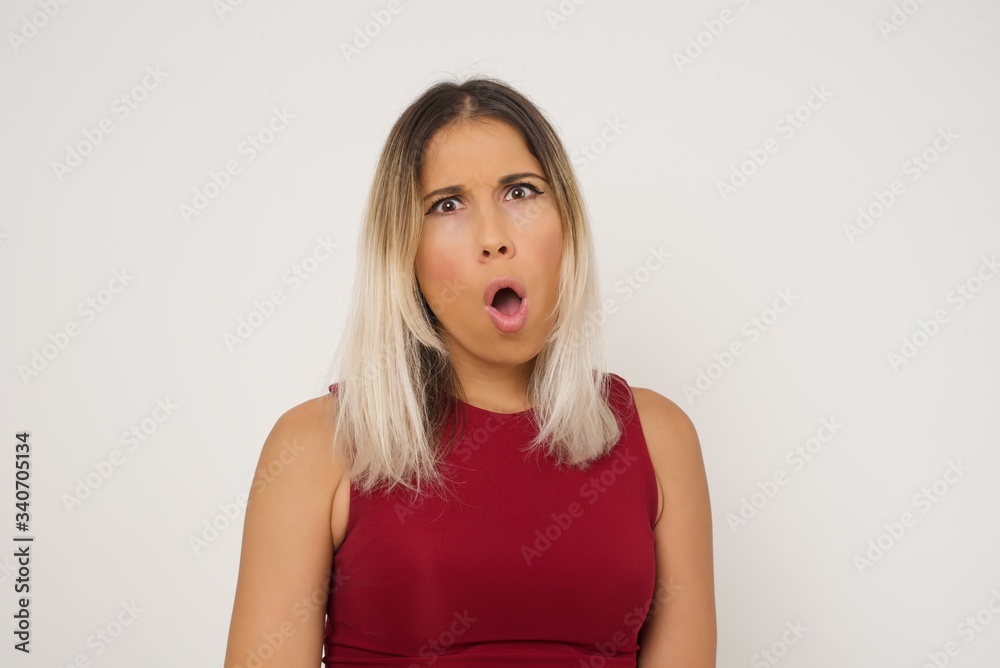 Expressive facial expressions. Shocked stupefied female, keeps jaw dropped, feels stunned from what she sees aside on blank gray Wall Expressive facial expressions. Shocked stupefied female, keeps jaw dropped, feels stunned from what she sees aside on blank gray Wall