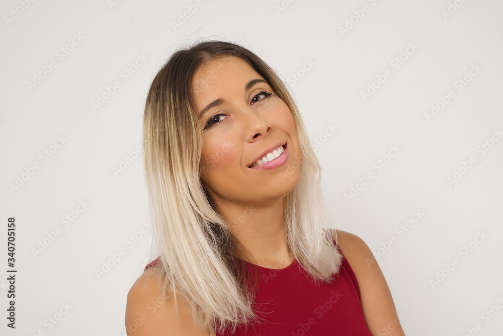 Shy girl smiling looking to the camera. Caucasian charming girl sanding against gray studio background feeling shy. Shy girl smiling looking to the camera. Caucasian charming girl sanding against gray studio background feeling shy.