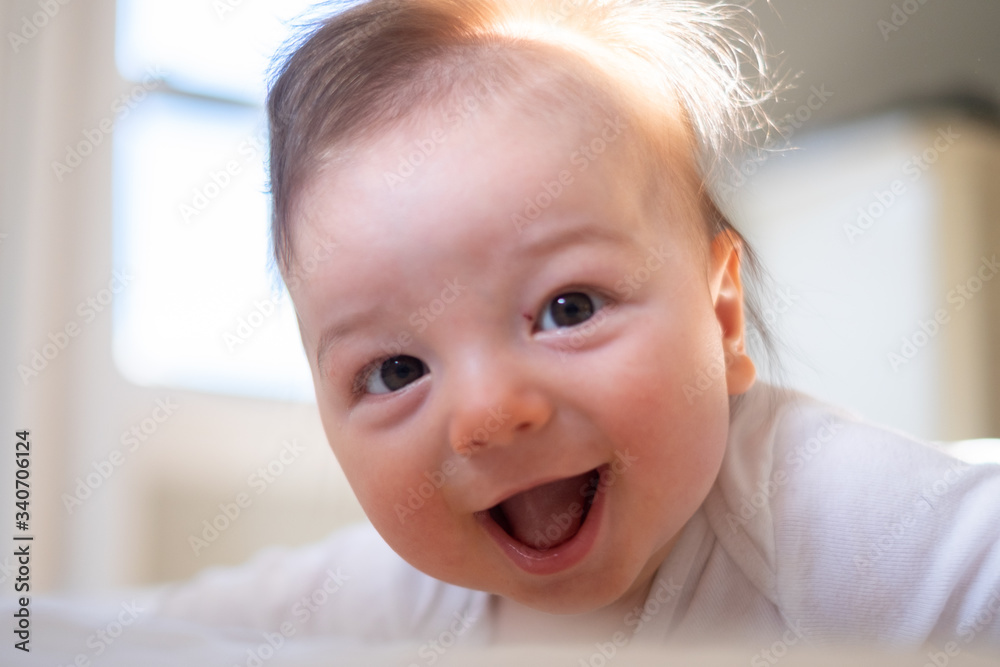 Portrait of a baby boy in the bedroom with bright light