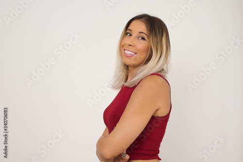 Image of cheerful pretty young caucasian businesswoman standing indoors with arms crossed. Looking and smiling at the camera. Confident girl.