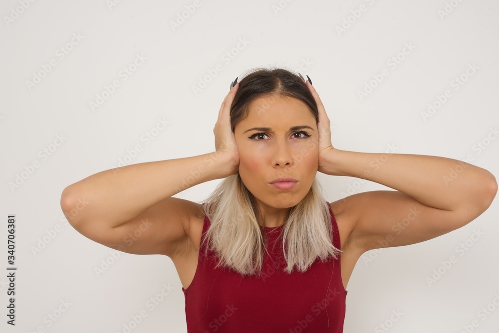 Woman plugging ears with hands does not wanting to listen hard rock or loud music. European Young female ignoring noise or din covering her ears with hands avoiding loud sounds at street. Woman plugging ears with hands does not wanting to listen hard rock or loud music. European Young female ignoring noise or din covering her ears with hands avoiding loud sounds at street.
