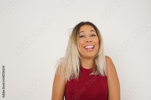 People and sudden reaction concept. Surprised caucasian beautiful female student, shrugs shoulders, looking sideways, being happy and excited about new plans with friends. Isolated over gray wall.