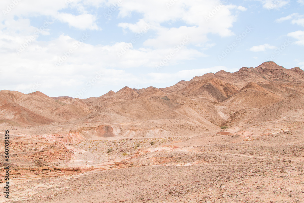 Desert, red mountains, rocks and cloudy sky. Egypt, color canyon.