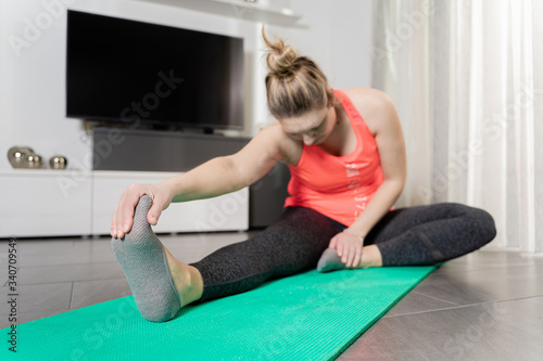 Curvy, blonde Caucasian woman practicing sport at home in a quiet and smiling way.