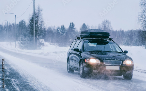 Car with roof rack and winter snowy road in Rovaniemi reflex
