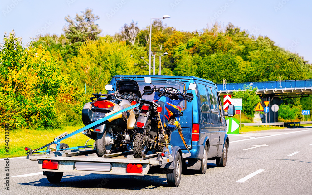 Naklejka premium Mini van with motorcycles on trailer in Road Slovenia reflex