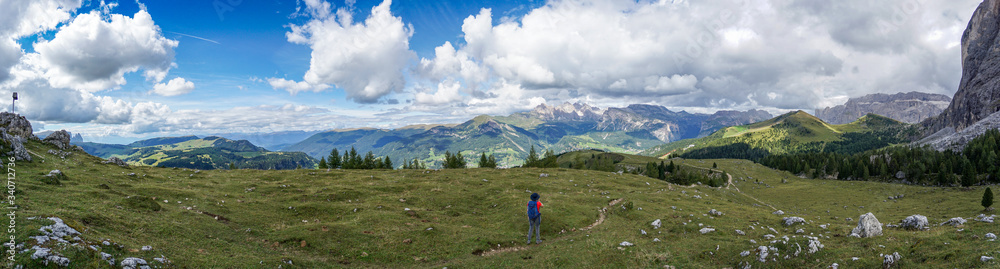 Wonderful panoramic view: Young sporty hiker woman hiking in beautiful dolomite mountain scenery