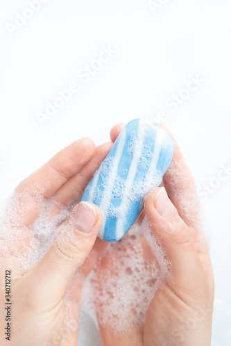 Blue soap in female hands, on a white background. Close up 