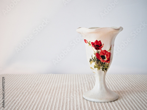 white vase decorated with floral motif of poppies on light background