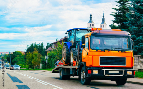 Obraz na plátně Truck trailer transporter with hauler carrying tractor on road Poland reflex