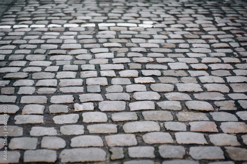 The gray paving stones close up. The texture of the old dark stone. Vintage, grunge. Road surface.