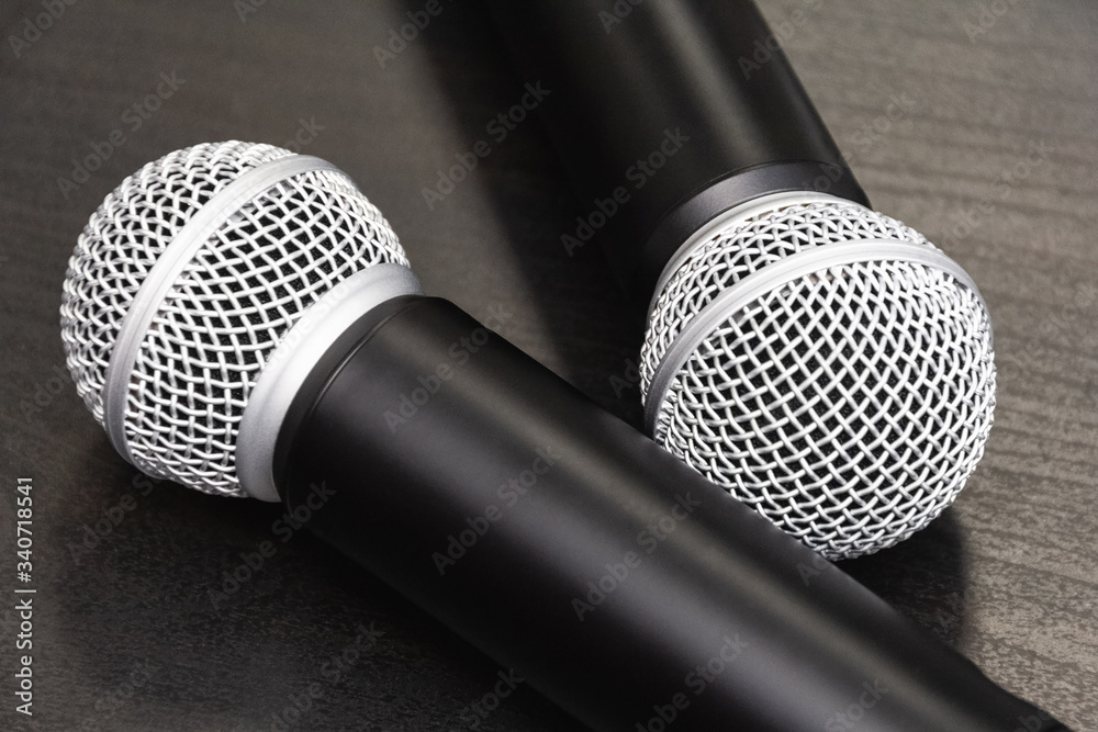 Obraz premium Top view: two microphones lie on a wooden table. Preparation before speaking at the conference