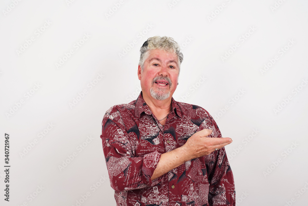 Positive glad male says: wow how exciting it is, has amazed expression, shows something on blank space with open hand over isolated gray background. Advertisement concept. Positive glad male says: wow how exciting it is, has amazed expression, shows something on blank space with open hand over isolated gray background. Advertisement concept.