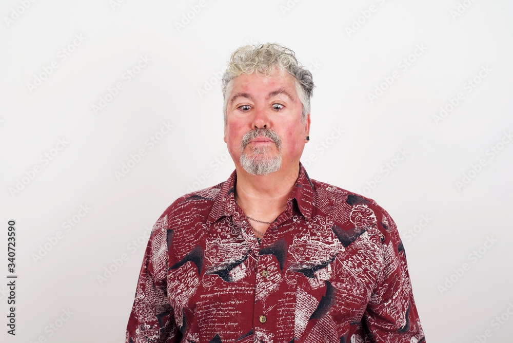 Funny comic guy crosses eyes, puts lips, makes grimace, foolishes after all day studying. Clueless man nerd with awkward expression has fun alone, plays fool. Wears white sweater Funny comic guy crosses eyes, puts lips, makes grimace, foolishes after all day studying. Clueless man nerd with awkward expression has fun alone, plays fool. Wears white sweater