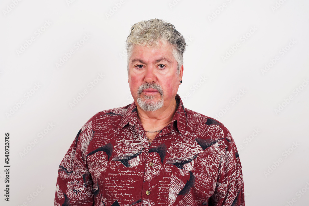Portrait of outraged young man with oval face, blue eyes wearing White T-shirt frowning his eyebrows being displeased with something. Scowling pretty female isolated over grey. Portrait of outraged young man with oval face, blue eyes wearing White T-shirt frowning his eyebrows being displeased with something. Scowling pretty female isolated over grey.