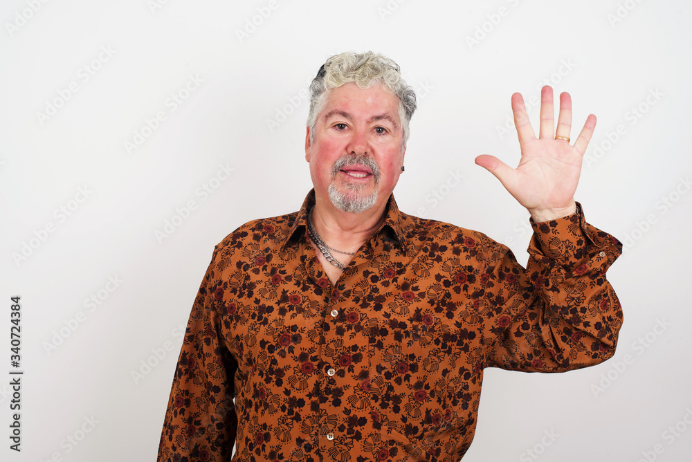 Young man standing against gray wall showing and pointing up with fingers number five while smiling confident and happy. Young man standing against gray wall showing and pointing up with fingers number five while smiling confident and happy.