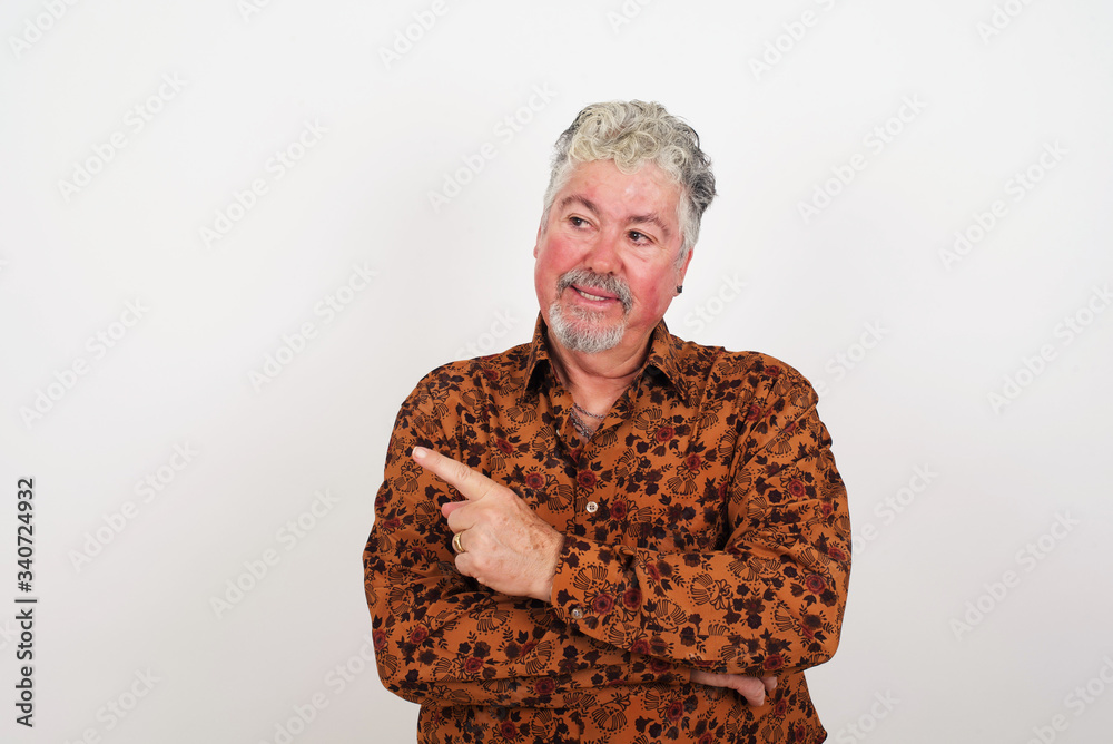 Portrait of young man posing on camera with tricky look and gesturing to side. Male designer presenting lovely product with index finger. Gesture concept. Portrait of young man posing on camera with tricky look and gesturing to side. Male designer presenting lovely product with index finger. Gesture concept.