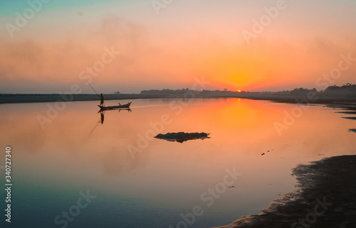 A Fishermen with his boat on the River Brahmaputra at Sunset.