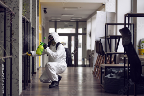 Cleaning and Disinfection at town complex amid the coronavirus epidemic. Professional teams for disinfection efforts. Infection prevention and control of epidemic. Protective suit and mask