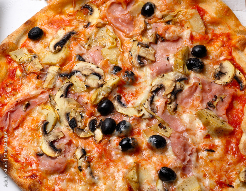 Pizza capricciosa con olive nere funghi prosciutto mozzarella e pomodoro.