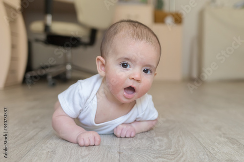 Newborn baby. A little boy in white clothes. Beautiful portrait of a toddler. Big-eyed baby.