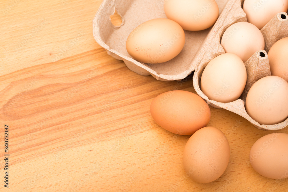 brown chicken eggs in an open cardboard box with eggs on a wooden table. Natural healthy food. brown chicken eggs in an open cardboard box with eggs on a wooden table. Natural healthy food.