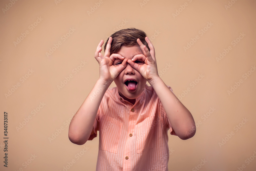A portrait of kid boy showing okay gesture and tongue. Children and emotions concept A portrait of kid boy showing okay gesture and tongue. Children and emotions concept
